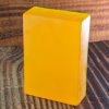Energising Essence: Lemon & Peppermint Essential Oil Glycerine Soap A bright yellow glycerine soap bar with a white edge, set against a wooden backdrop, enriched with lemon and peppermint essential oils.